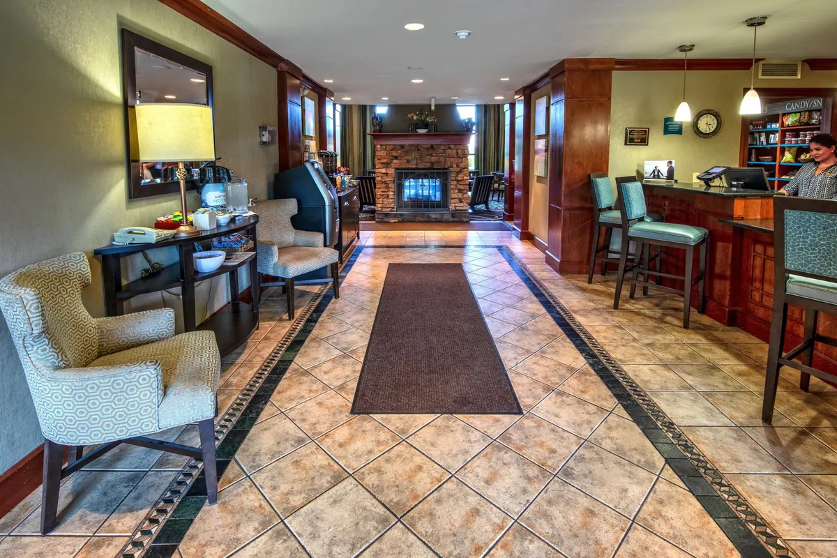 This image highlights a living area with a fireplace, comfortable seating, and a decorative lamp, adjacent to the reception desk. The warm, inviting ambiance is perfect for relaxing after a day out, catching up on shows, or gathering for movie nights—echoing the multifunctional living space described in the content.